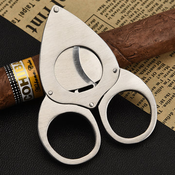 A person carefully using a guillotine cutter to trim the cap of a premium cigar, demonstrating the correct technique for a clean, precise cut. This image highlights the importance of proper cigar cutting for an optimal smoking experience.